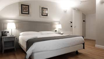 A hotel room with a large bed, two bedside tables with lamps, a wardrobe, and two framed pictures on the wall.