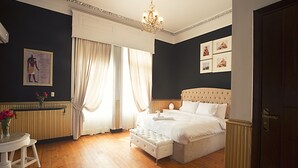 A bedroom with a large bed, a chandelier, and a window with curtains. - Tahrir Plaza Suites (Cairo)