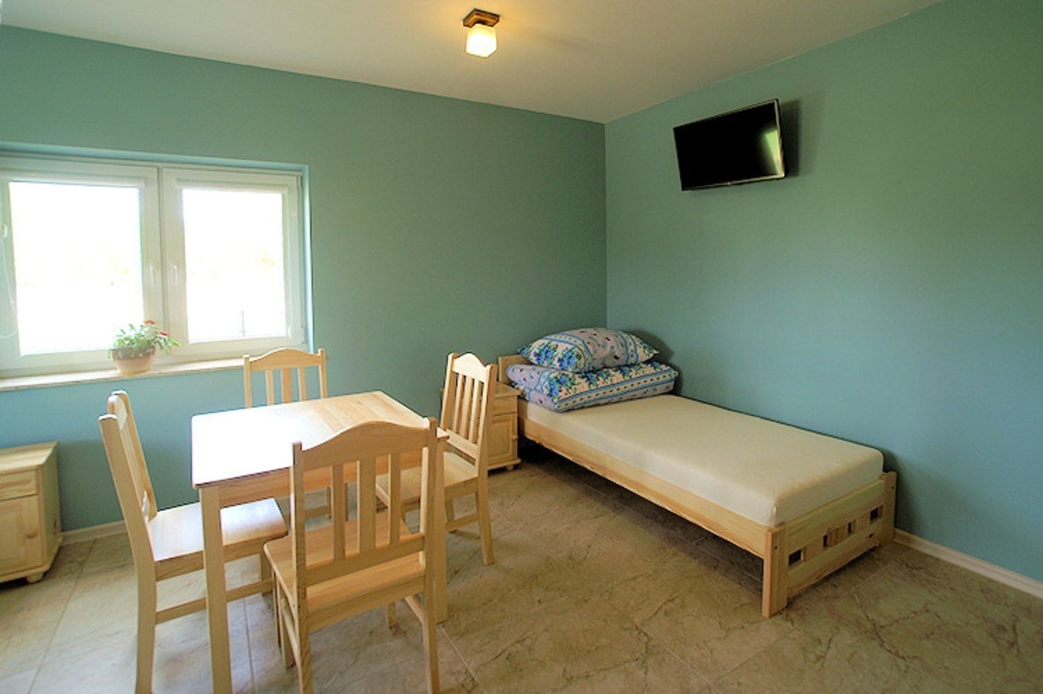 A room with a bed, a desk, and a chair.