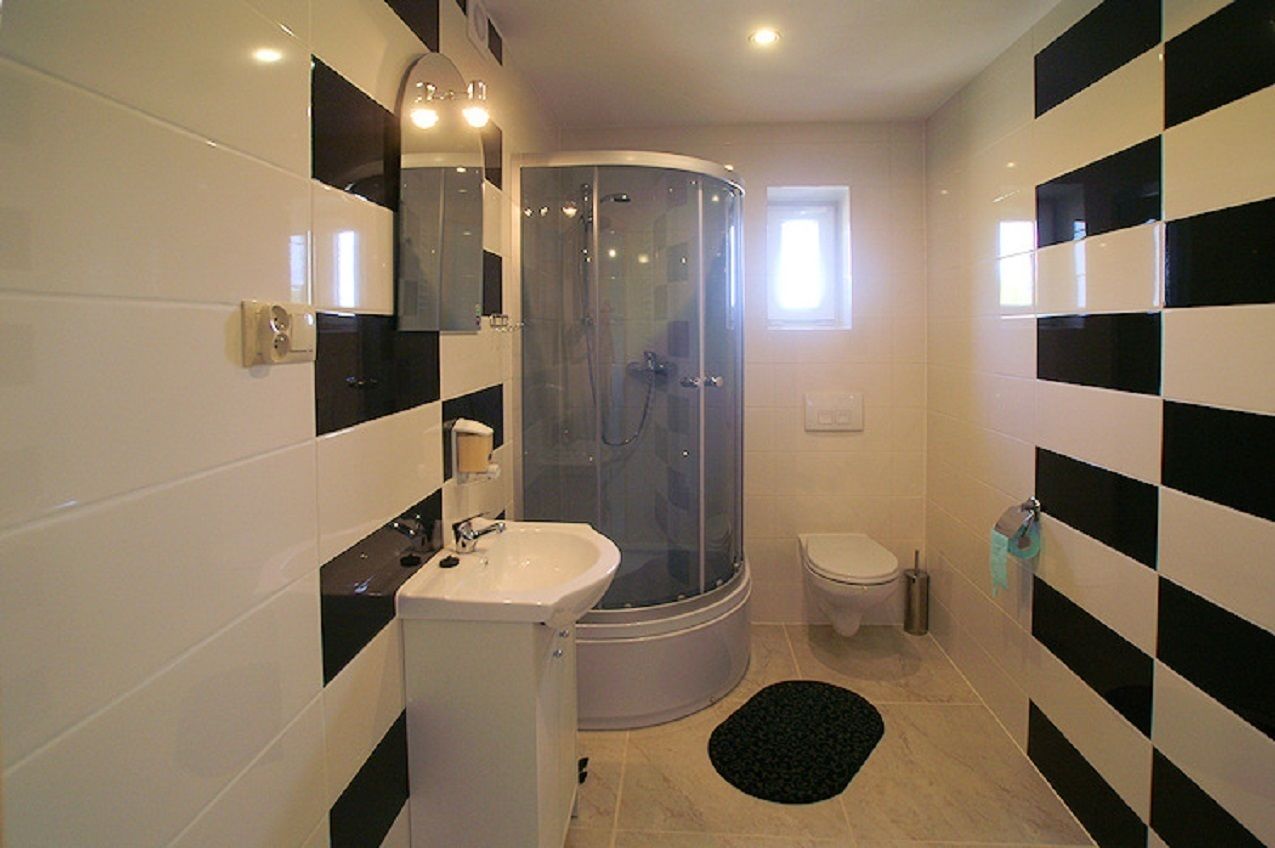 Un baño moderno con ducha de vidrio, lavamanos e inodoro.