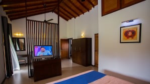 Une chambre d’hôtel comprenant un lit, une télévision, une armoire et un bureau avec une chaise.