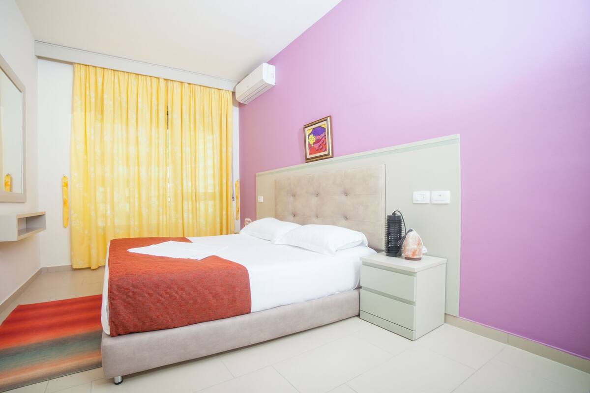 Une chambre d’hôtel avec un lit, une table de chevet et une petite table d’appoint.