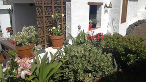 A white building with a wooden door, potted plants, and a small window. - Nice country house with terrace, sea and mountains views (Tigaday)