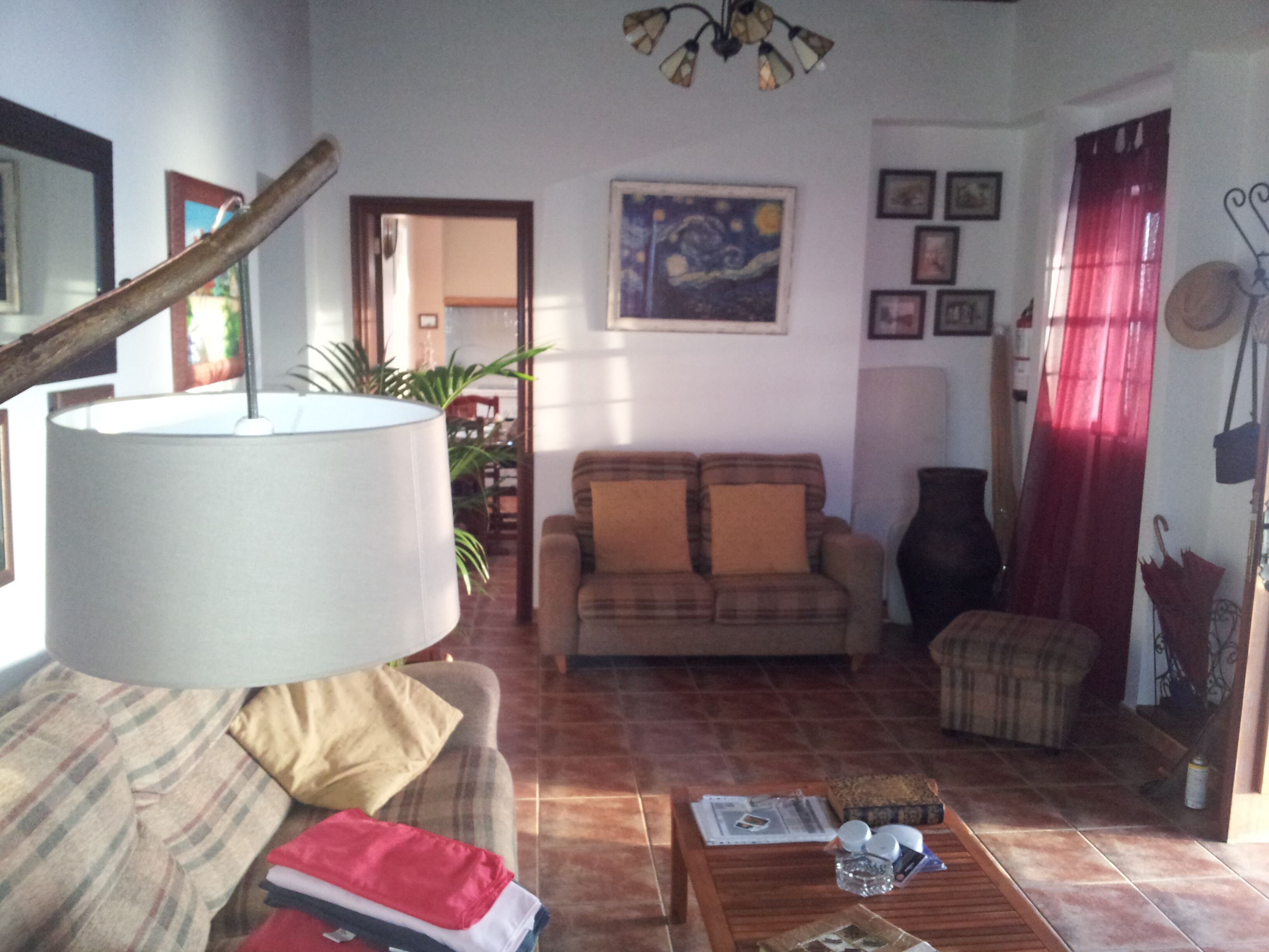 A living room with a sofa, a coffee table, a lamp, and a painting on the wall.