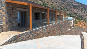 A stone building with a glass balcony overlooking a mountainous landscape. - Mountain and Private Beach VILLA EAGLE  2-10 pers. (Chavgas)
