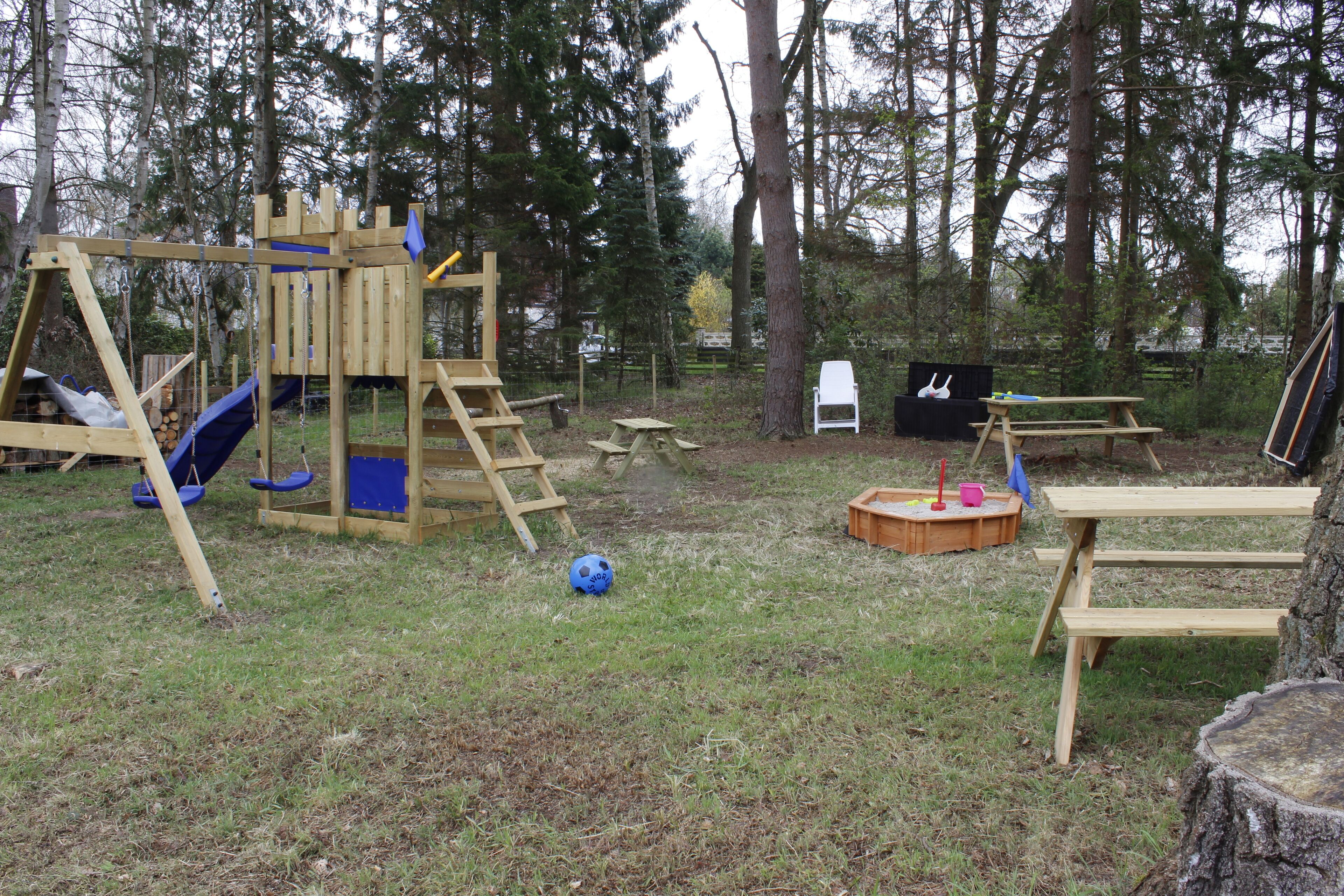 A playground with a swing set, slide, and climbing structure.