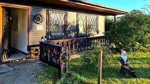 Un bâtiment en bois doté d’un balcon, d’un petit jardin et d’une statue de gnome.