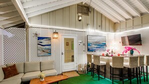 A room with a green carpet, white walls, a sofa, a dining table with chairs, and artwork. - Hidden Gem! Vista 4B, Private, Outdoor Living, Spacious, Work Crews & Families (Vista)