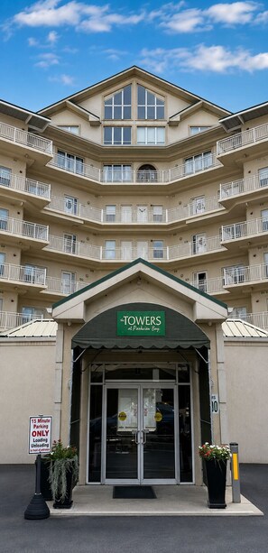 A multi-story hotel with a green awning displaying the name 'The TOWERS at Parkview Bay.'