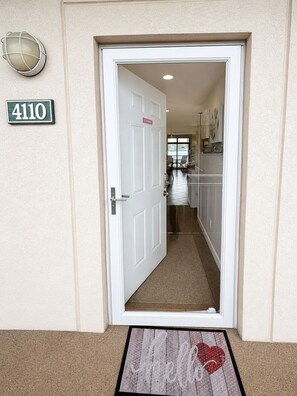 A hotel entrance with a white door, a number sign '4110', and a doormat with 'Hello' and a heart. - Top-Rated Walk-In Lakefront Condo indoor and outdoor Pools, Hot Tub & Sauna (Osage Beach)