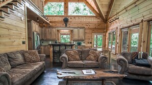 A spacious cabin interior with a wooden interior, a kitchen area, and seating arrangements. - Blue Ridge Mountain Serenity at The Summit: Hot Tub, Tubing & Hiking Trails (Blue Ridge)