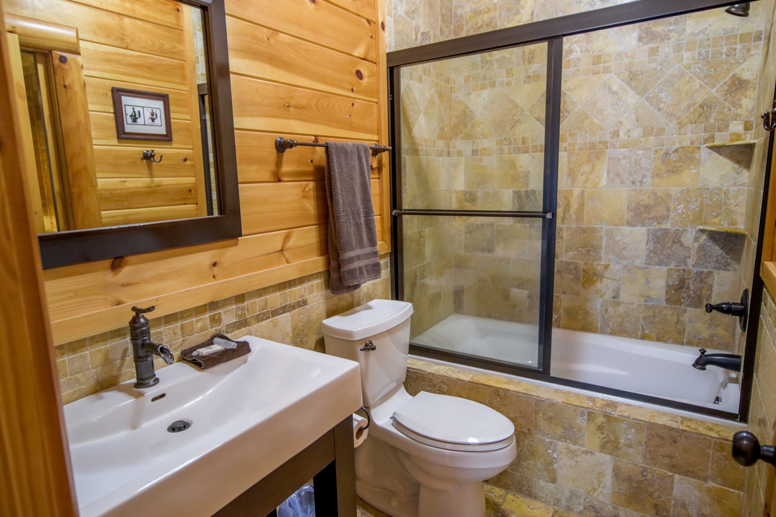 Un baño con tocador de madera, inodoro, bañera y cabina de ducha.