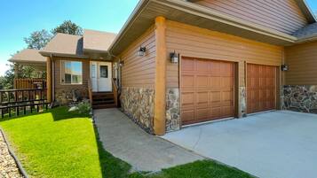 A two-story house with a stone facade, a front porch, and a garage.