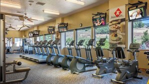A gym with treadmills, elliptical machines, and weight equipment.