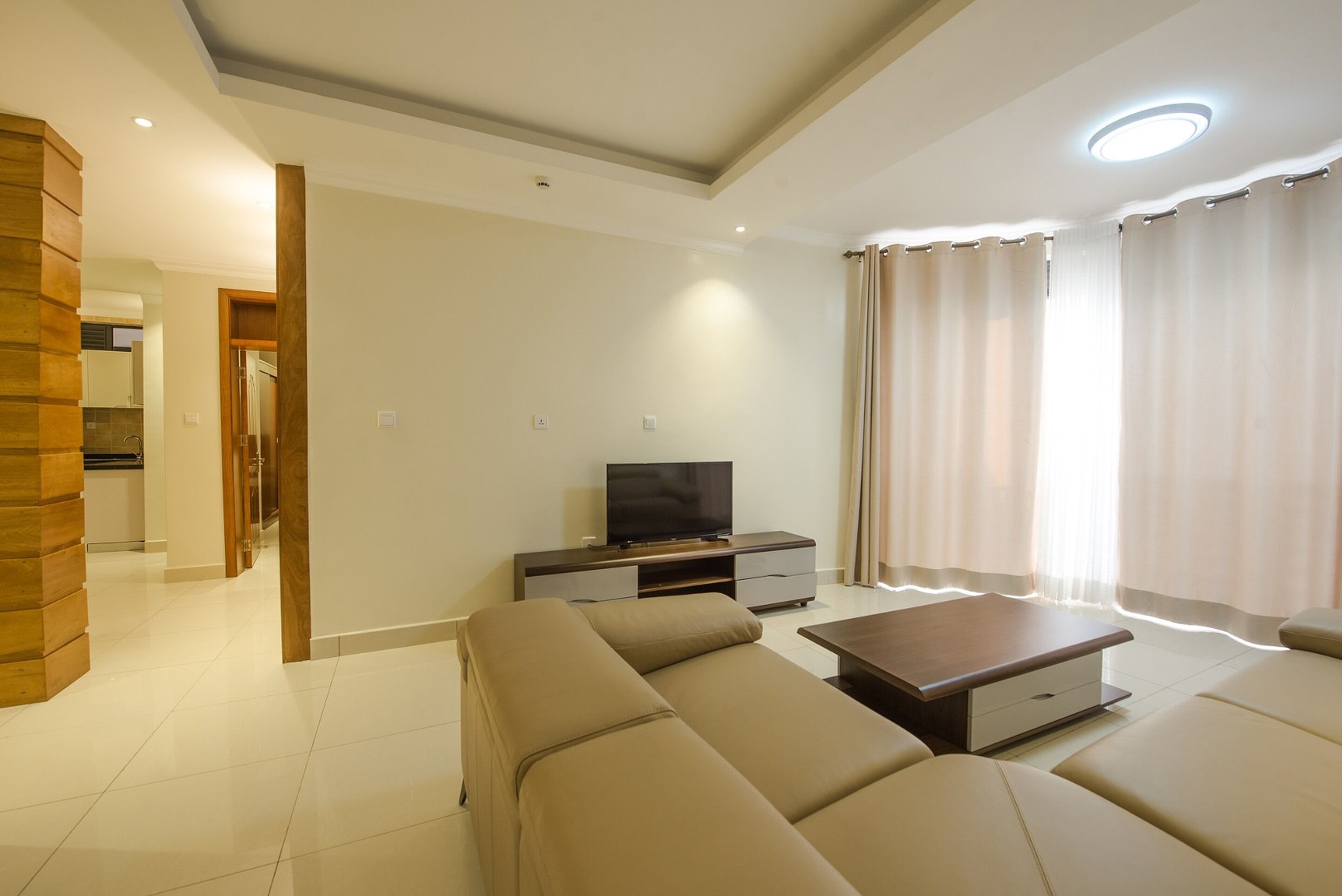 A modern living room with a sofa set, a coffee table, and a TV on a stand.