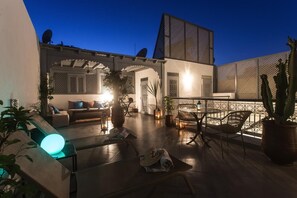 Un espace extérieur aménagé en terrasse, avec des sièges, une table et des plantes en pot.