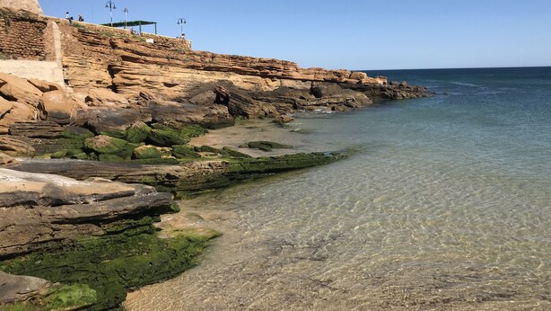 A coastal landscape with rocky cliffs and clear shallow waters. - Cozy Apartment with Stunning Sea Views, One Minute Walk from the Beach (Praia da Luz, Lagos)