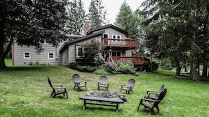 A house with a deck, surrounded by a grassy yard and trees. - Country Escape! 5 bed/5bath, 2 acre pond, pool/Foosball tables, Fire pit, Sauna (Roxbury)