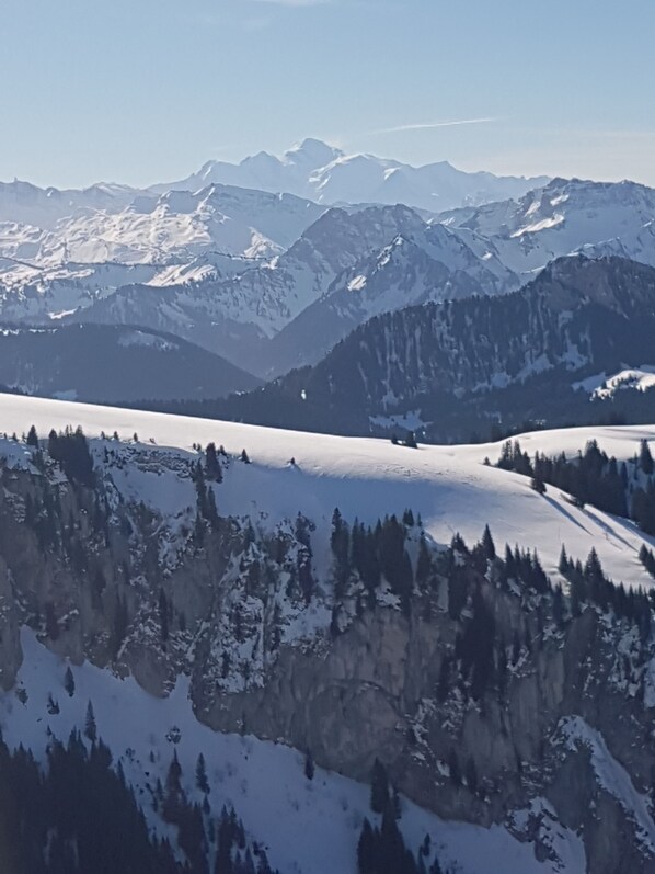 A mountainous landscape with snow-covered peaks and a valley. - Studio Flat, Sleeps 4. Doorstep skiing with spectacular views and location. (Bernex)