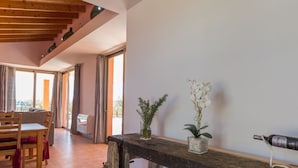 A spacious room with a wooden bench, a table, and two potted orchids.
