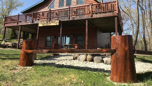 A wooden cabin with a covered porch and a sign reading "Hana Log Cabin". - Hana Log Cabin near Devil's Lake (Baraboo)