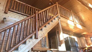 A wooden staircase with a handrail leading to a second floor. A sign above the staircase reads "St. Louis' Place." - Hana Log Cabin near Devil's Lake (Baraboo)