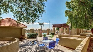 Un espace extérieur aménagé avec une terrasse, une piscine, des coins salon couverts et une pergola.