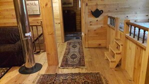 A wooden interior with a staircase, a rug, and a wall-mounted teapot. - Ultimate relaxing vacation  (Orwell)