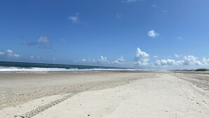 A wide sandy beach with footprints leading to the ocean. - Peaceful Getaway with Amazing Views - Cape Lookout & Beaufort nearby - SLEEPS 8 (Davis)