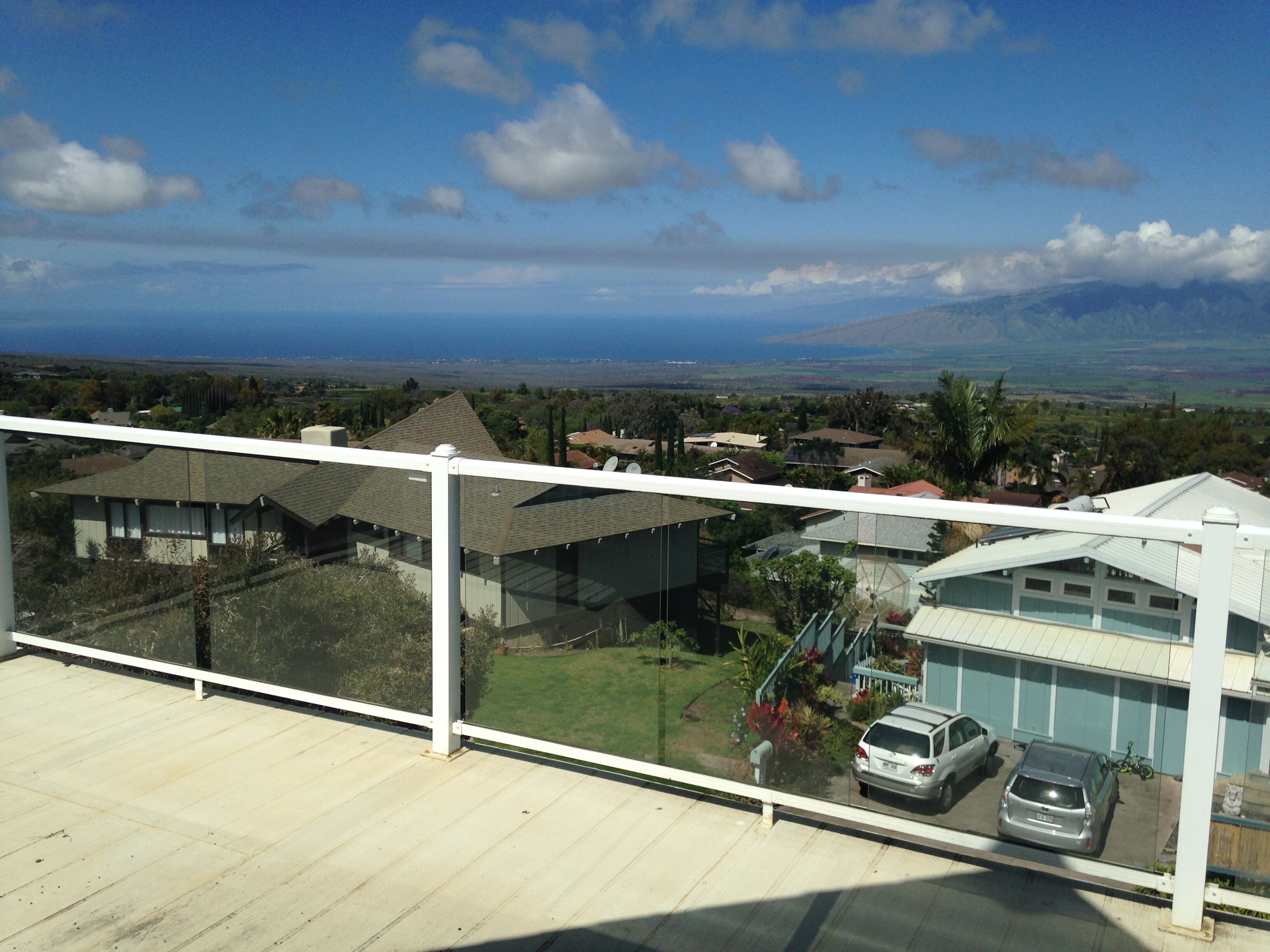 A residential area with houses, a clear sky, and a view of the ocean.