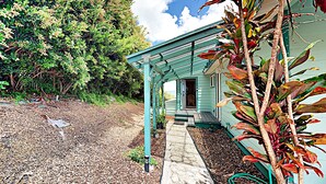 A house with a porch, surrounded by trees and a gravel path. - Haleakala Sunrise Home, Kula, Maui, Hawaii (Kula)