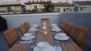 A dining table set for six with wooden chairs, white tableware, and candles. - Enjoy the beach life! Walk to beach and pier+Roof Deck& Garage in Hermosa Beach (Hermosa Beach)