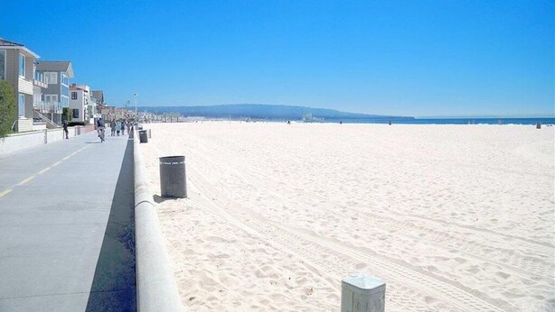 A beach with a concrete walkway, buildings on one side, and a clear sky. - Enjoy the beach life! Walk to beach and pier+Roof Deck& Garage in Hermosa Beach (Hermosa Beach)