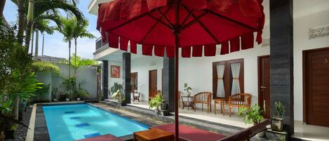 Una piscina al aire libre, tumbonas