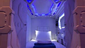 A futuristic room with a bed, a control panel, and a window. - PassGo Digital Airport Hotel Terminal 3 Soekarno Hatta (Tangerang)