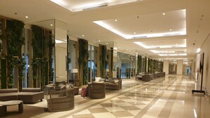 Un hall amplio con suelo a cuadros, muebles modernos y jardines verticales.