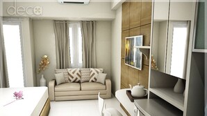 Una habitación moderna y luminosa con sofá, mesa de comedor y sillas. Cuenta con una zona de cocina con estufa y microondas.