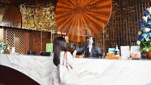 A reception desk with a wooden circular sign that reads "LUMINOR".