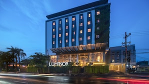 A modern hotel with a prominent entrance, multiple floors, and a well-lit facade.