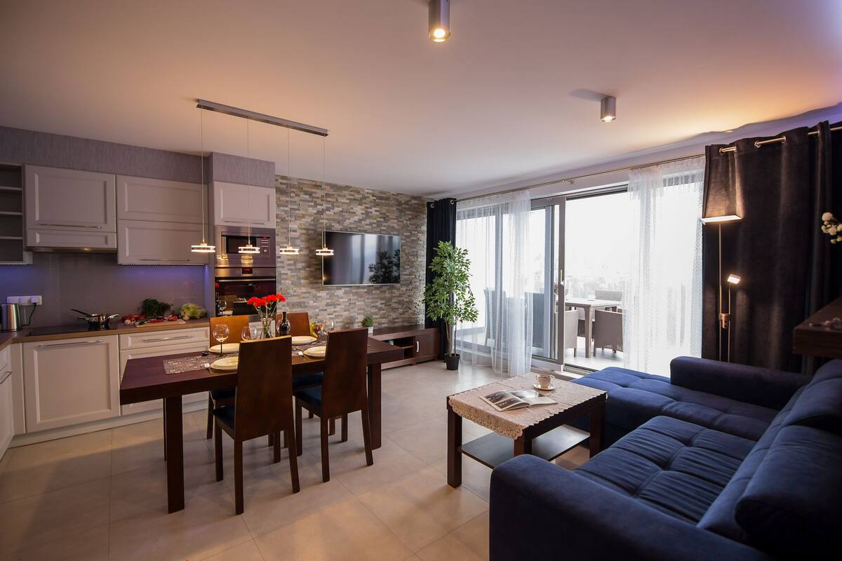 A modern apartment with a kitchen, dining area, and living room.
