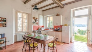 A spacious kitchen with a dining area, large windows, and a view of the outdoors. - 2 bedroom awesome home in Orta San Giulio NO (Orta San Giulio NO)