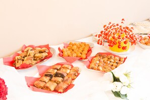 A table with various food items, including pastries and a cake with cherries on skewers. - Morfeo Luxury Rooms (Pozzallo)