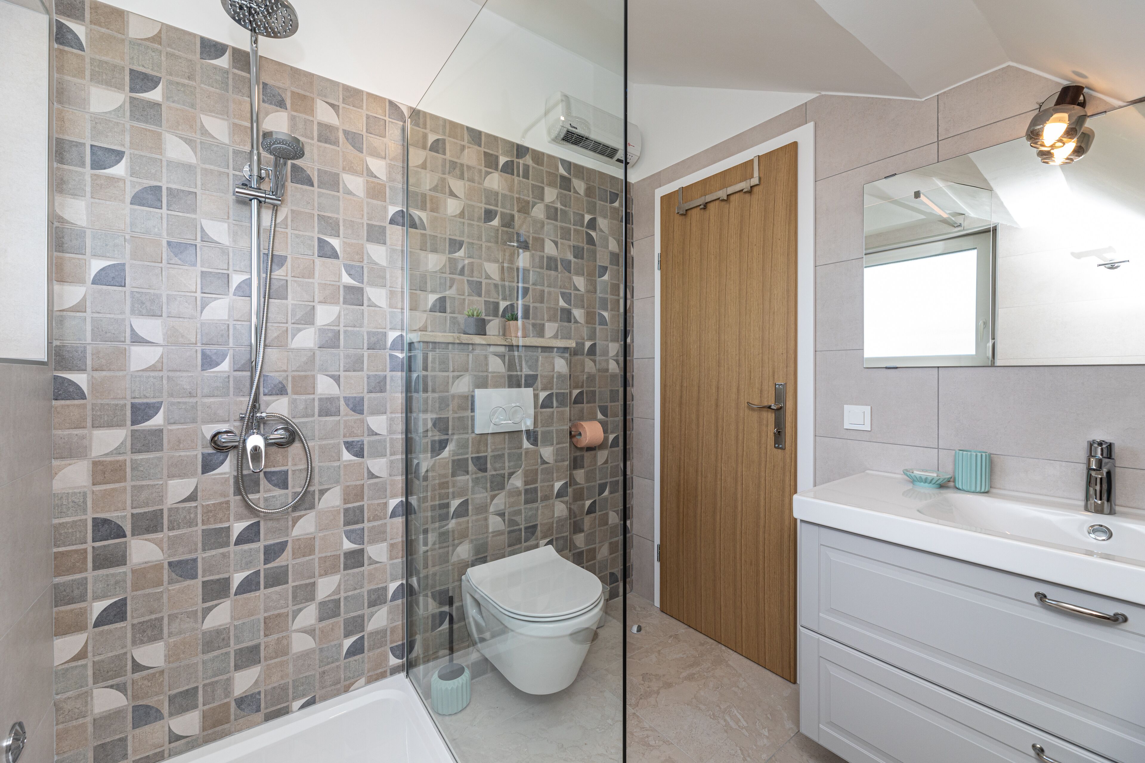 Un baño moderno con ducha, inodoro y tocador.