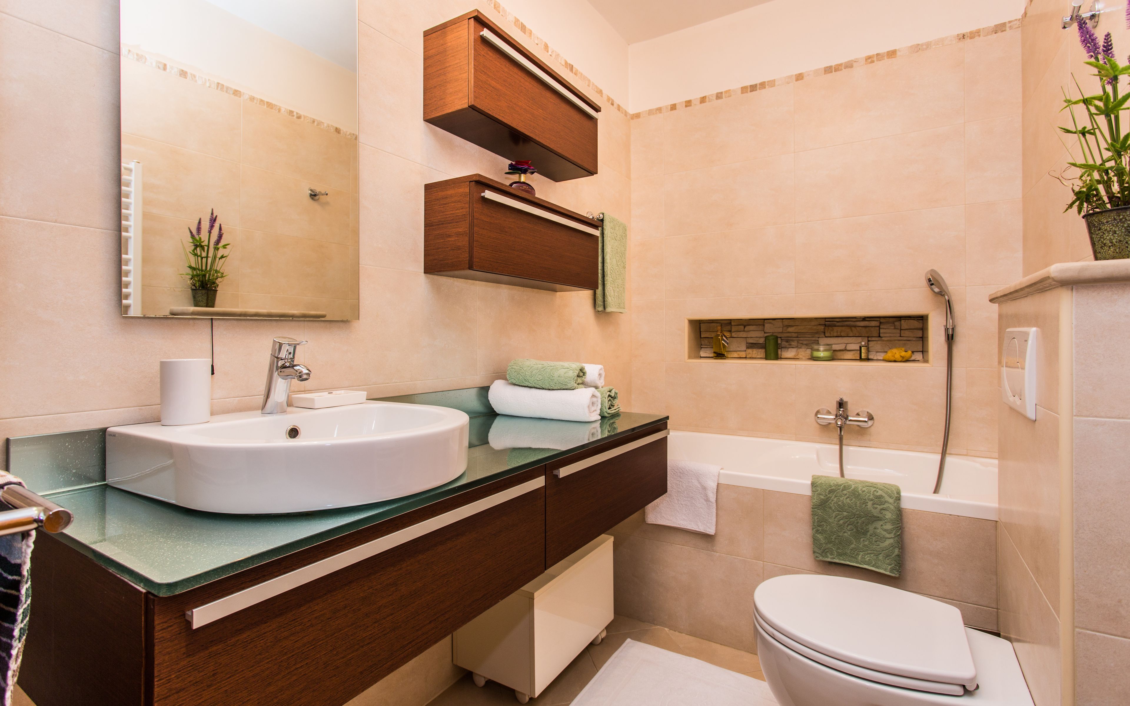 Ein modernes Badezimmer mit einem großen Waschbecken, Waschtisch, Spiegel und einer Badewanne.