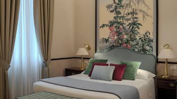 Une chambre à coucher bien rangée, avec un lit, des tables de chevet, un banc et un grand tableau floral accroché au mur.