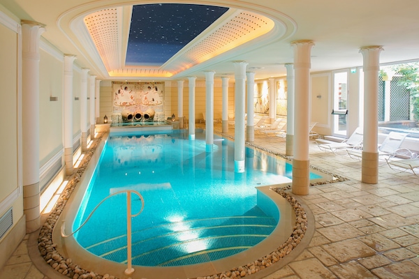 Una piscina techada, sillones reclinables de piscina