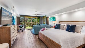 Un dormitorio moderno con una cama grande, un sofá, un escritorio y vistas al exterior.