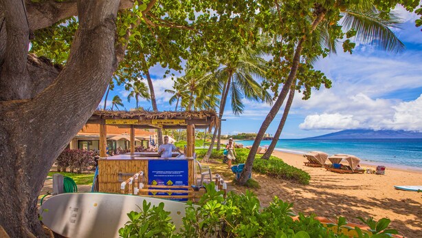 Un restaurante frente a la playa con terraza, piscina y vistas al océano.
