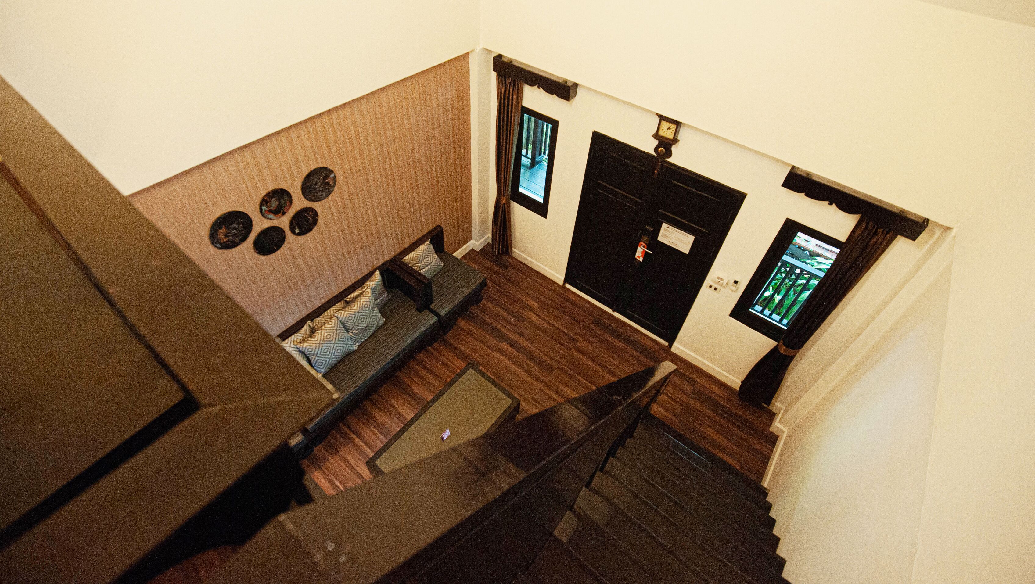 A staircase leading to a room with a sofa, a small table, and a window with a view.