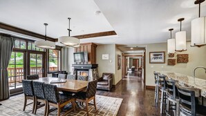 A spacious dining area with a wooden table and chairs, a fireplace, and a view of the outdoors.
